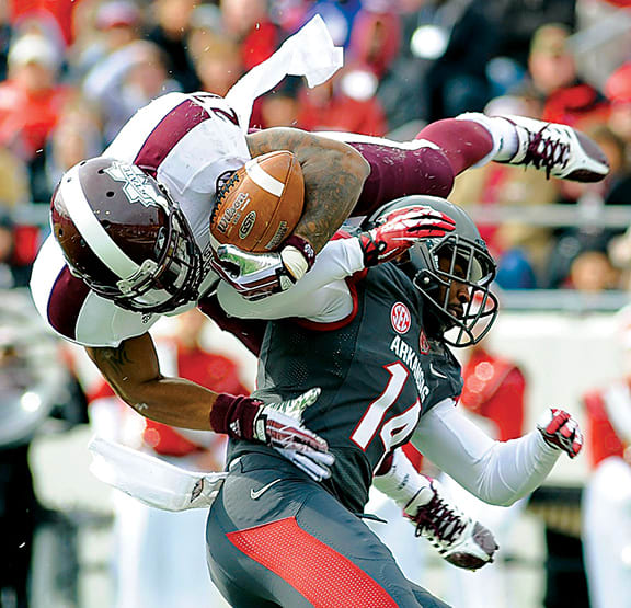 Mississippi State Bulldogs running back LaDarius Perkins (27) dives into the end zone against Arkansas Razorbacks safety Eric Bennett (14) during the second quarter at War Memorial Stadium.